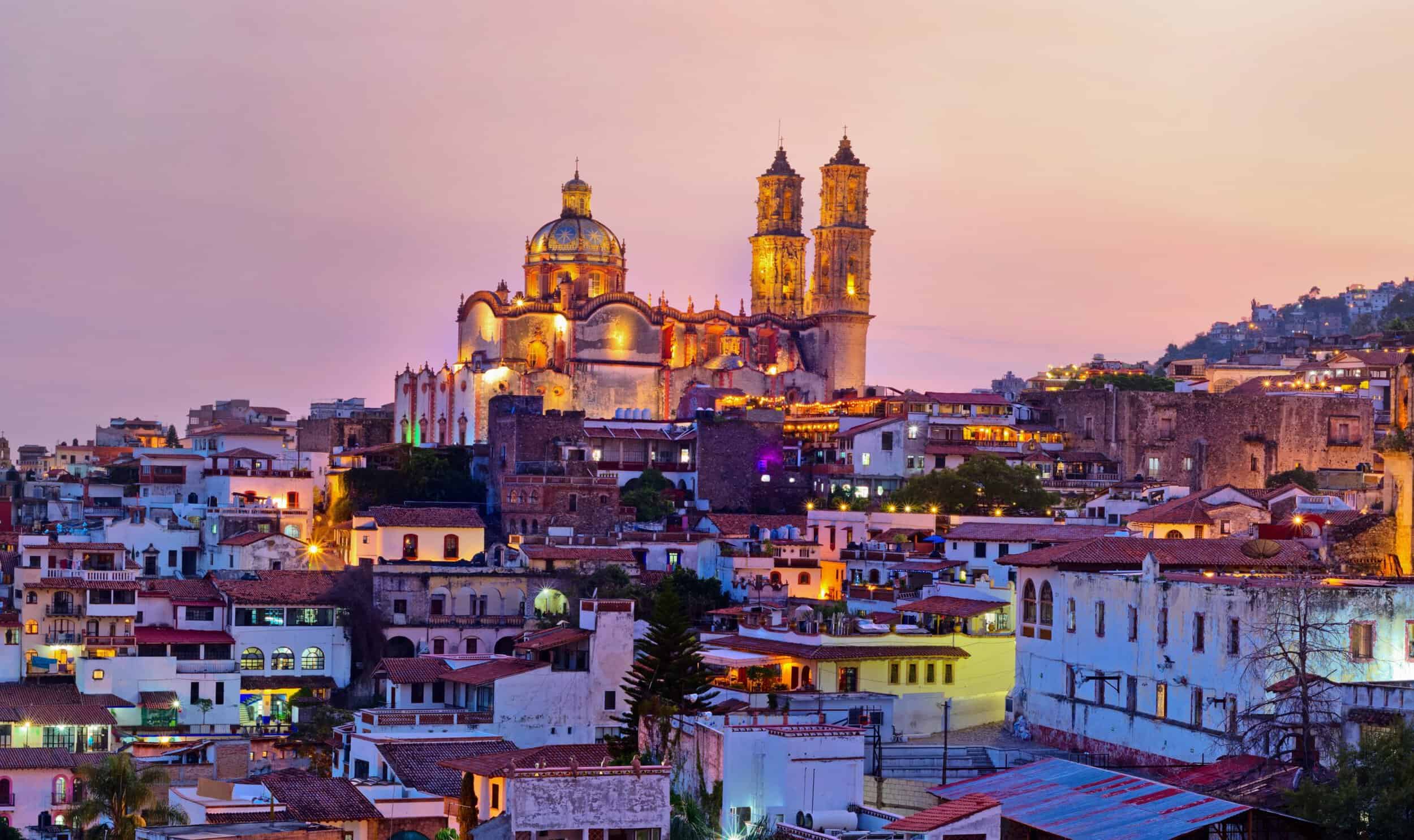 Elegant cityscape of EMWA Valle featuring a historic cathedral illuminated at sunset.